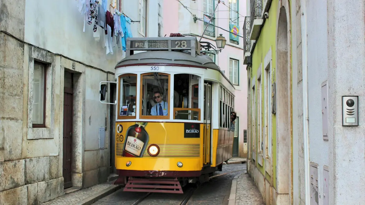 Tranvía amarillo 28 subiendo por una calle estrecha de Alfama Lisboa